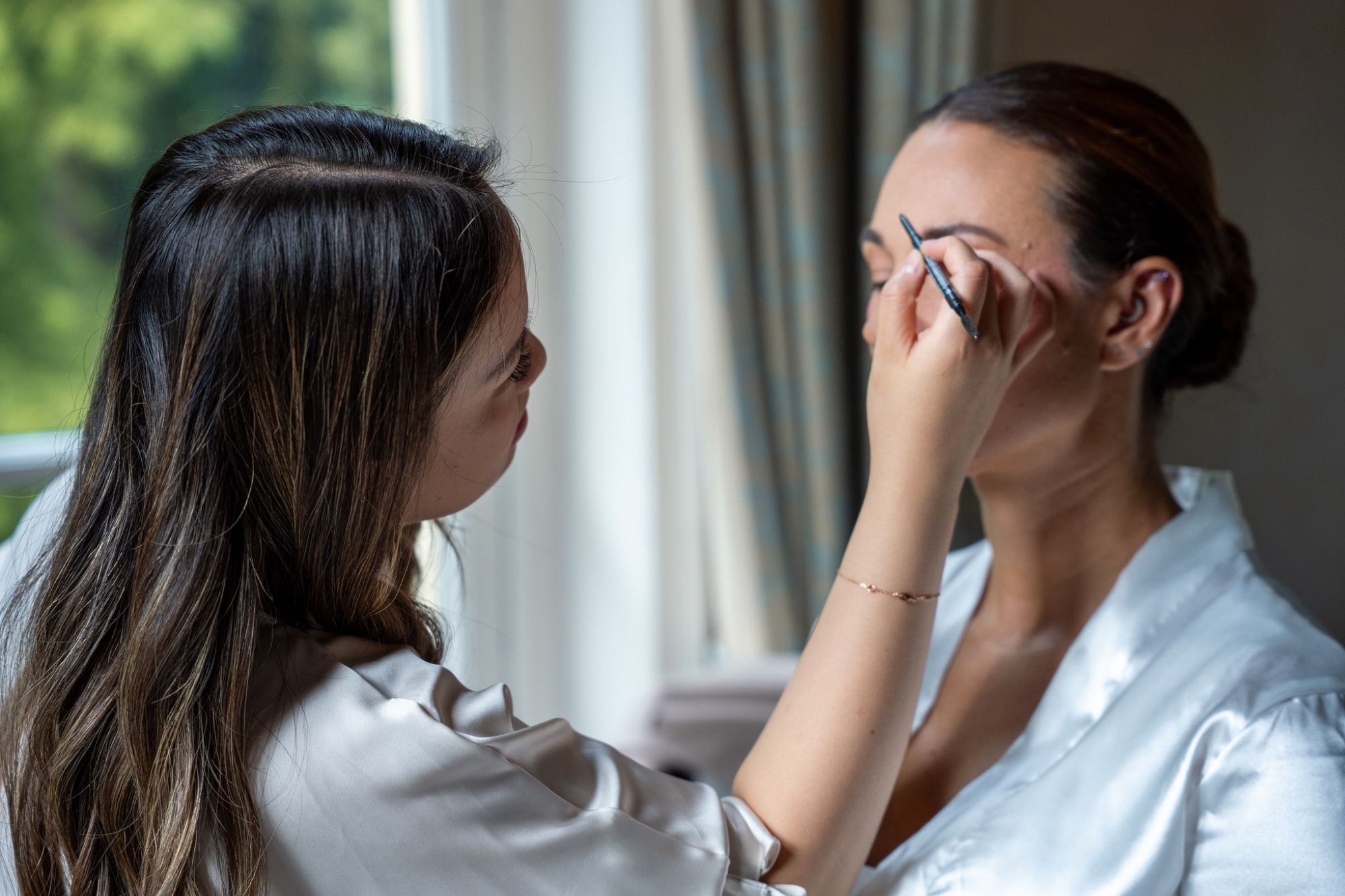 Visagist werkt aan de make-up van de bruid
